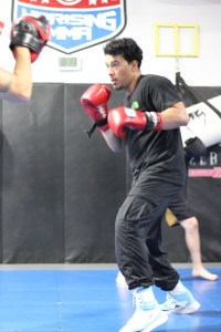 An athlete training in boxing gloves at Uprising MMA